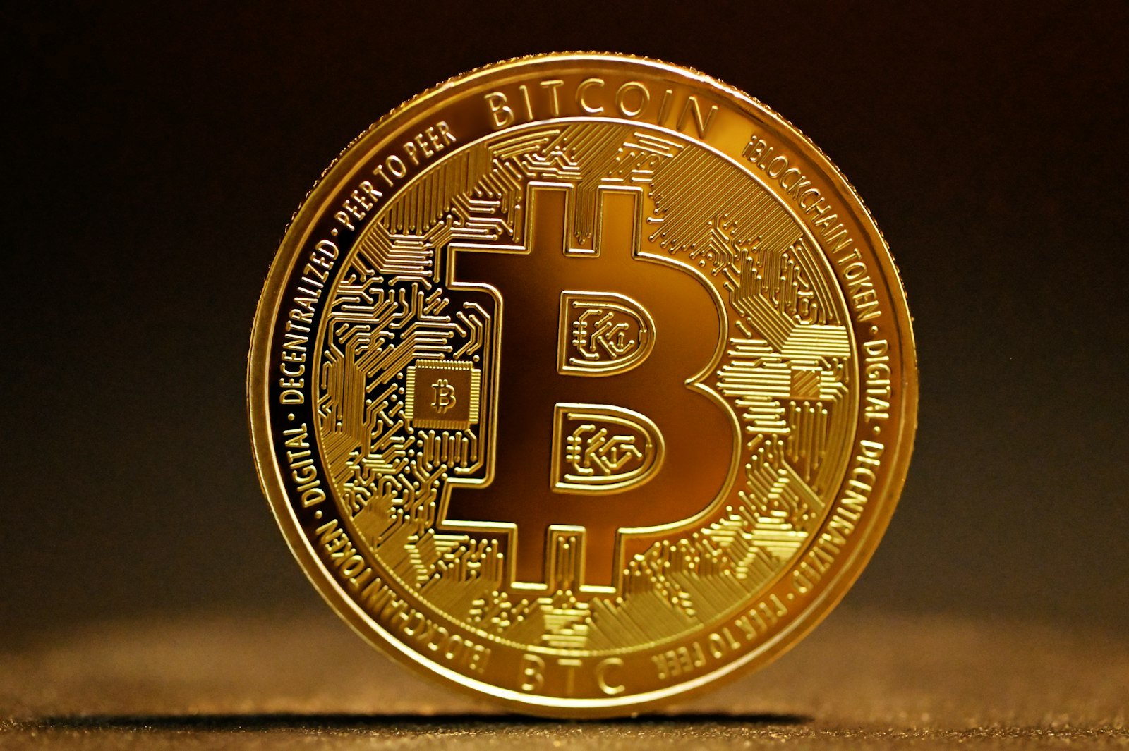 A gold coin in front of a trading screen